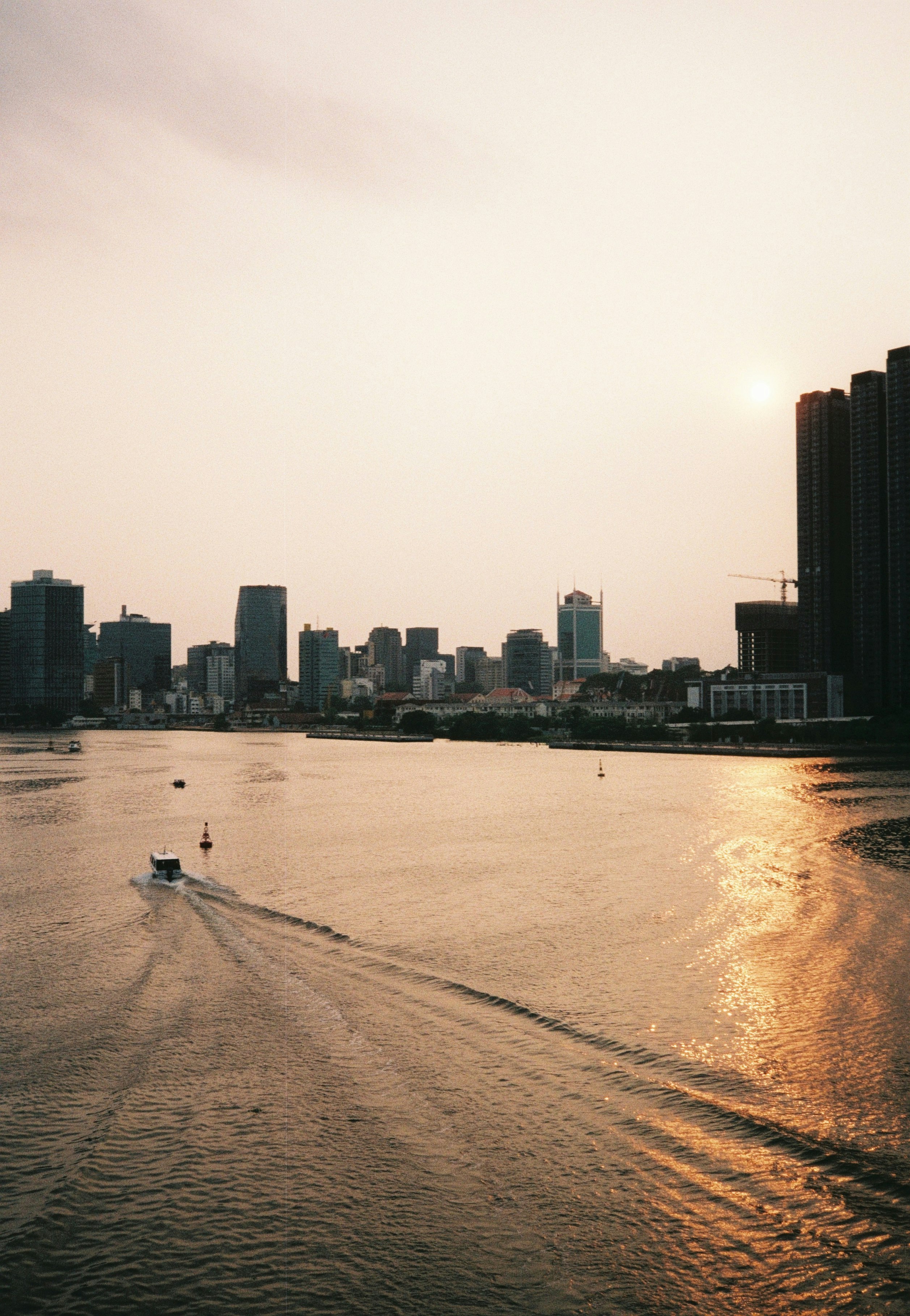 person riding on boat on sea near city buildings during daytime